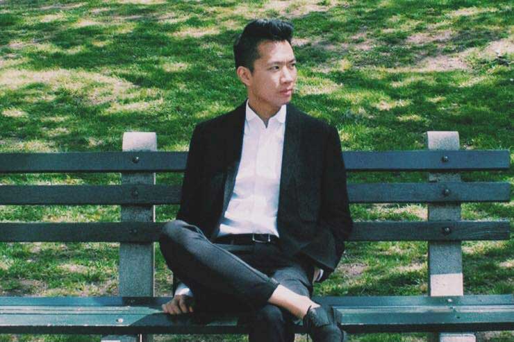 Senior Graphic Designer, Mike Nguyen relaxing on a park bench