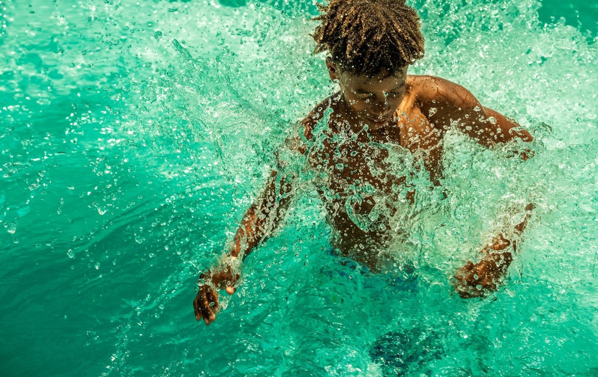 Young man splashing at water park